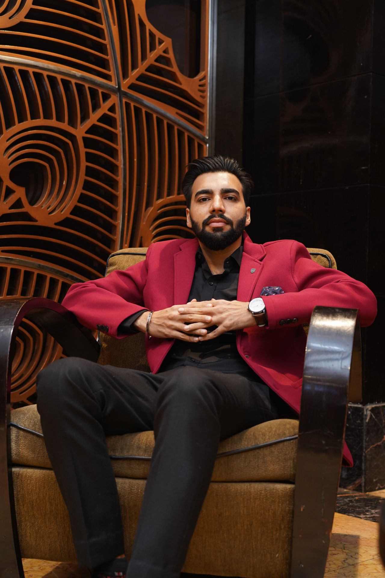 Revaansh Kohli seated in a lounge chair wearing a red blazer