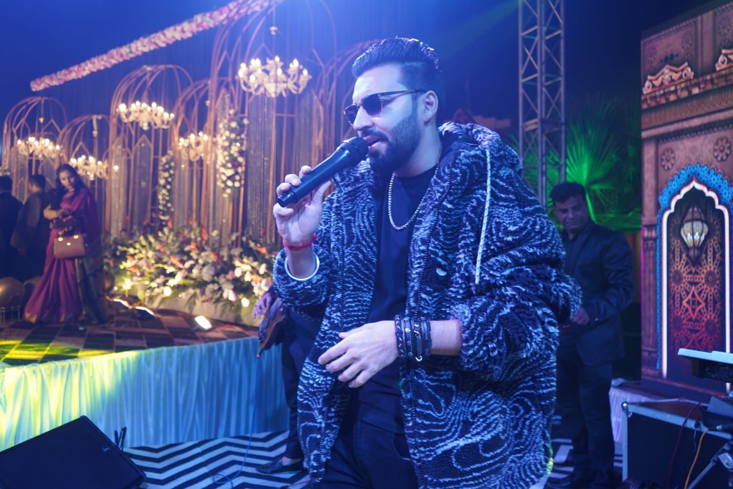 Revaansh Kohli singing at an evening event under stage lights
