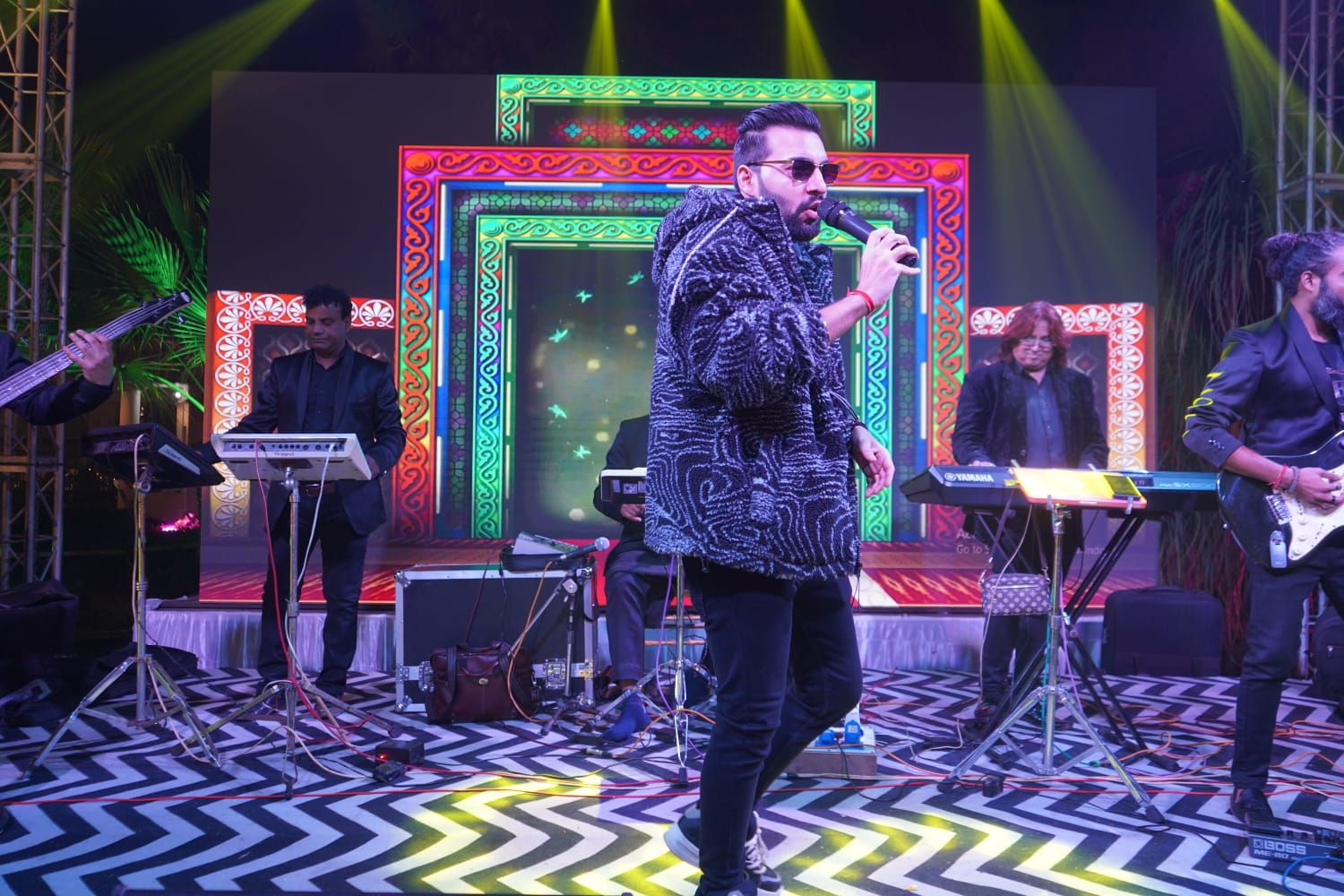 Revaansh Kohli and band performing under green and gold stage lights