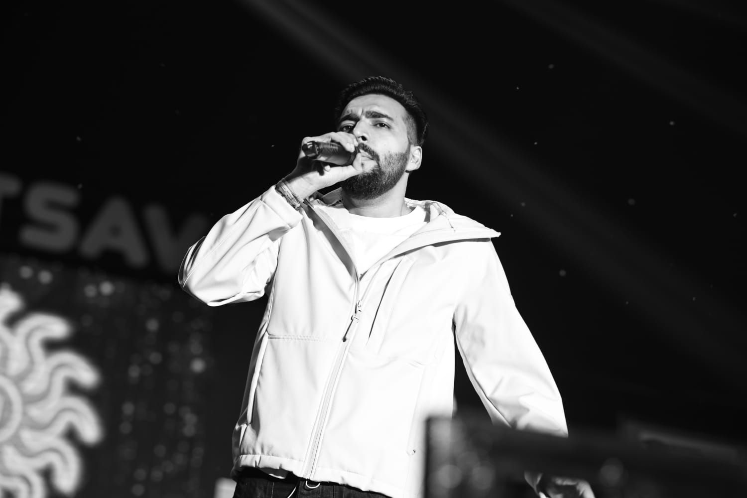 Monochrome shot of Revaansh Kohli singing into the microphone